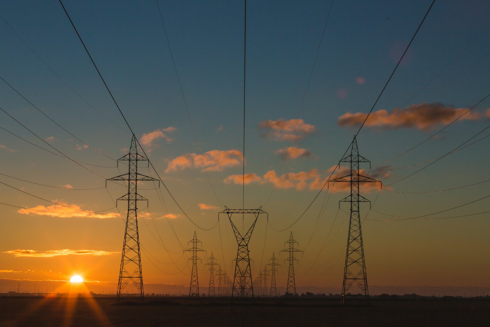 High-voltage grid transmission lines at sunset